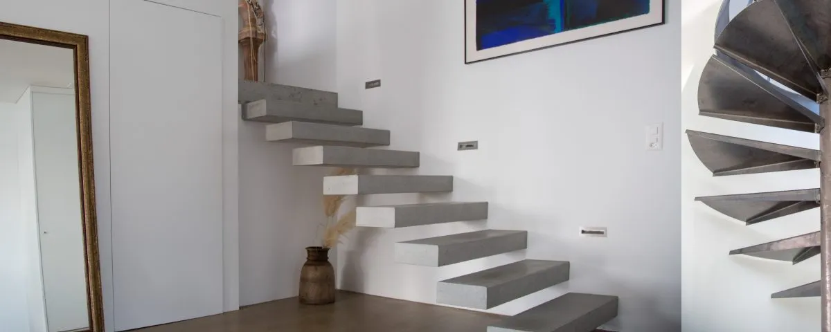 Treppenaufgang mit freitragenden Betonstufen und dekorativer Wandgestaltung